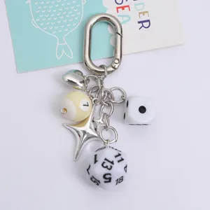 Close-up detail of the creative dice and heart charm keychain with silver metal finish