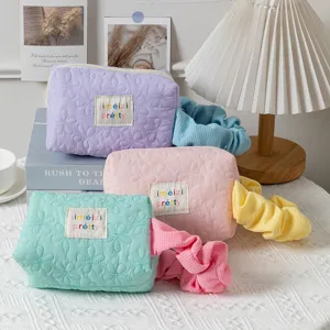 Quilted candy-colored makeup bags with floral patterns and matching pleated handles