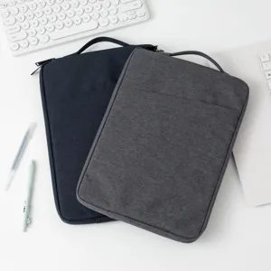 Hochwertige Laptophüllen aus Stoff in Blau und Grau auf einem weißen Schreibtischset