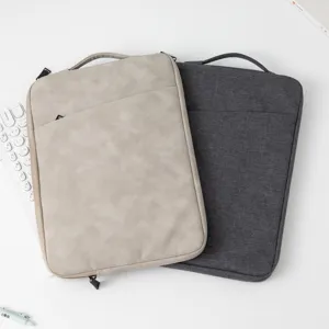 Detailansicht von zwei minimalistischen Laptophüllen in Beige und Grau auf dem Tisch