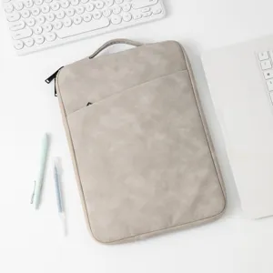 Draufsicht auf eine hochwertige graue Kunstleder-Laptophülle auf einem weißen Schreibtisch