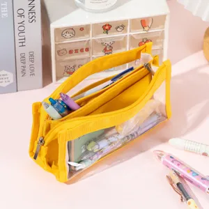 Close-up of a large yellow transparent pencil case with multi-compartments on a desk