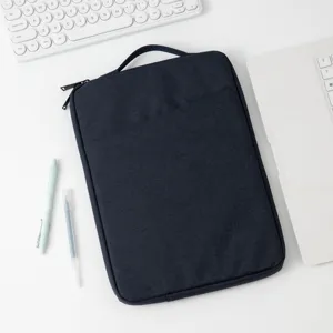 Minimalistische dunkelblaue Laptophülle auf weißem Schreibtisch mit Zubehör