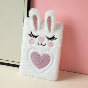 Close-up of cute white plush A5 notebook with rabbit embroidery and glitter heart
