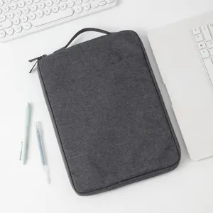Draufsicht auf eine dunkelgraue Tablet-Hülle aus Stoff mit Griff auf weißem Tisch