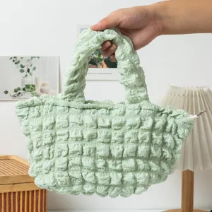 Bolso de mano verde menta con textura de burbujas rizadas y cierre de cremallera