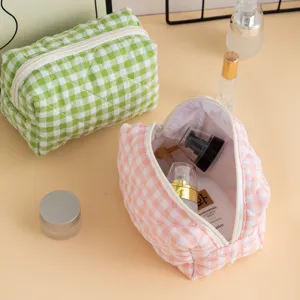 Close-up of open and closed quilted gingham cosmetic bags showing storage capacity