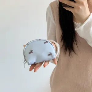 Close-up of a portable light blue cosmetic bag with cute dog prints and metal zipper.