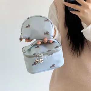 Close-up detail of light blue dog print cosmetic bags featuring silver heart zipper pulls