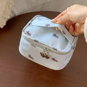 Detail of travel makeup bag featuring cute dog prints and decorative heart-shaped zippers