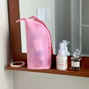 Close-up of pink mesh travel toiletry bag on a bathroom shelf for smart organization