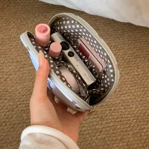 Detailed interior view of a portable makeup bag with polka dot lining and compartments