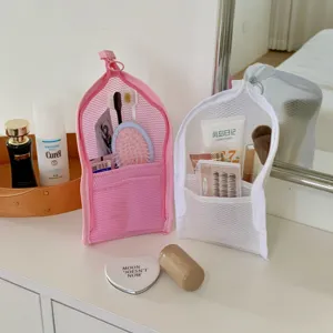 Detailed view of pink and white mesh travel storage bags holding various toiletries