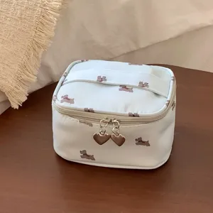 Small light blue cosmetic bag with cute dog pattern and heart-shaped zipper pulls.