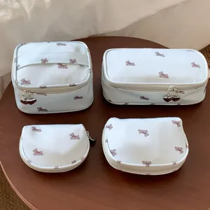 4-piece set of light blue travel makeup bags featuring cute small dog print and heart zippers