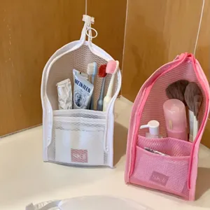 Detail view of mesh travel toiletry bags in pink and white for bathroom storage use