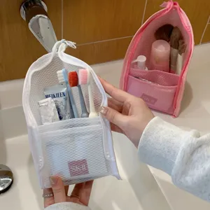 Close-up of portable white mesh storage bag holding travel toiletries in bathroom