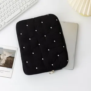 Detailed view of a black quilted tablet sleeve featuring elegant white polka dot embroidery