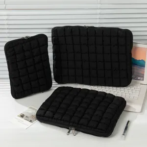 Drei Größen schwarzer gesteppter Cloud Cotton Laptoptaschen in einer Lifestyle-Schreibtischumgebung.