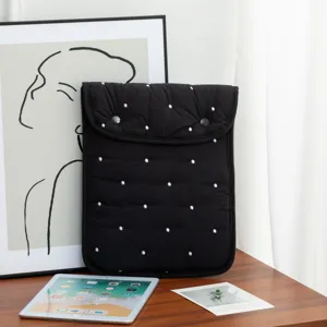 Primer plano de funda negra acolchada para tableta con lunares blancos y cierre de botones