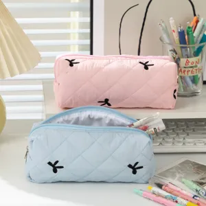 Detailed view of quilted large capacity pencil bags in pink and blue with bow embroidery