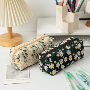 Nahaufnahme der feinen Gänseblümchen-Stickerei auf den großen Canvas-Kosmetiktaschen.