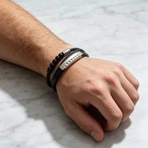 Gros plan sur le bracelet homme multicouche en perles noires et cuir avec accent en acier.