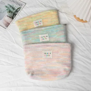 Dettaglio di trousse in peluche arcobaleno con patch colorati della marca 'sozakka beaute'