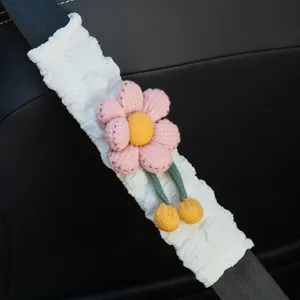 Detailansicht eines weißen Sicherheitsgurt-Schutzbezugs mit einer rosa Plüschblume.