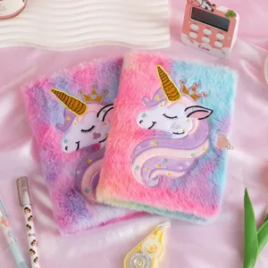 Λεπτομερής όψη βελούδινων ημερολογίων μονόκερου με κέντημα και κλειδαριές σε ροζ μετάξι.