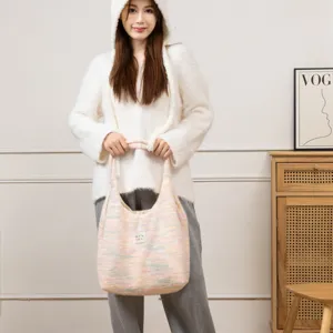 Modell mit weicher Plüsch-Stricktasche mit buntem Pastellmuster für den Winter.