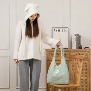 Asiatisches Model mit einer süßen Plüsch-Tragetasche in gemütlicher Atmosphäre, großer Shopper.