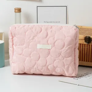 Detailed view of the elegant pink quilted flower pattern on this soft fabric cosmetic bag