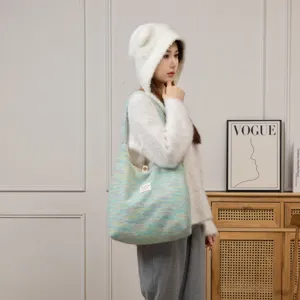 Asiatisches Model mit einer großen, flauschig gestrickten Tragetasche in gemütlicher häuslicher Umgebung