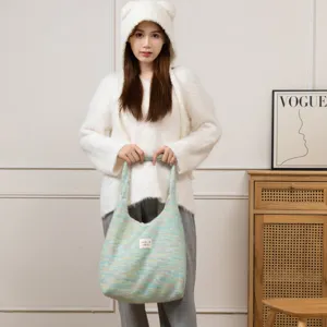 Asiatisches Model zeigt eine bunte, plüschige Strick-Einkaufstasche für Herbst und Winter