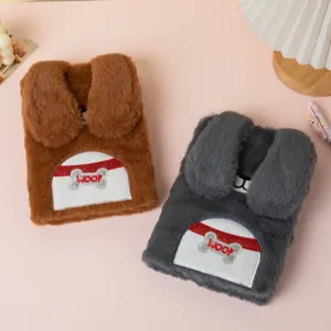 Close-up of cute plush dog-themed notebooks with floppy ears and WOOF embroidery