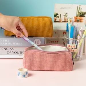 Trousse vintage en velours côtelé dans un décor de bureau avec des accessoires.