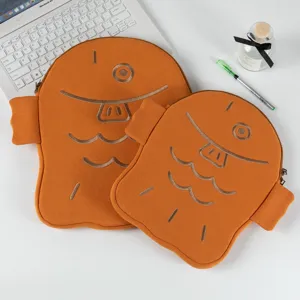 Cute Taiyaki shaped laptop and iPad sleeves in two sizes on a white desk setup.