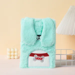 Close-up detail of a cute mint green plush notebook featuring a cartoon dog embroidery design