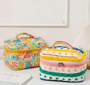 Close-up of two quilted colorful high-capacity cosmetic bags on a white desk.