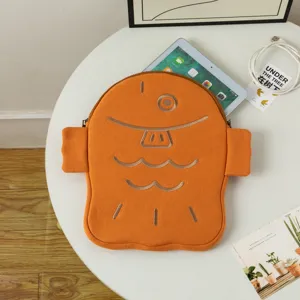 Detailed view of the orange fish-shaped Taiyaki tablet sleeve holding an iPad on a white table
