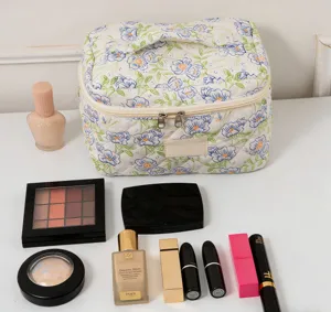 Macro view of large floral quilted makeup bag shown with assorted beauty cosmetics