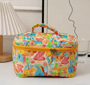 Colorful quilted cosmetic bag with rainbow hearts print and vibrant yellow zipper.