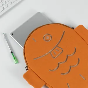 Close-up of an orange Taiyaki-shaped iPad sleeve with a silver tablet partially inside.