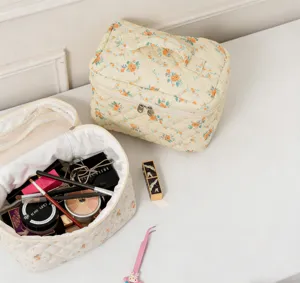 Detail of a floral quilted cosmetic bag showing spacious interior with makeup essentials.