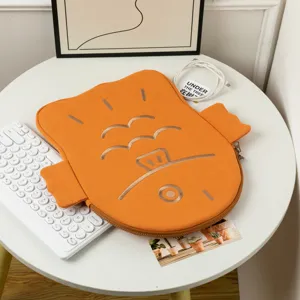Cute orange Taiyaki fish-shaped iPad sleeve with gold detailing and zip closure on white table