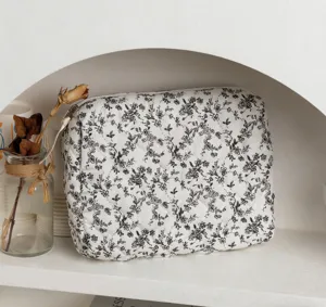 Detailansicht einer gesteppten Baumwoll-Kosmetiktasche mit Blumenmuster in Weiß.