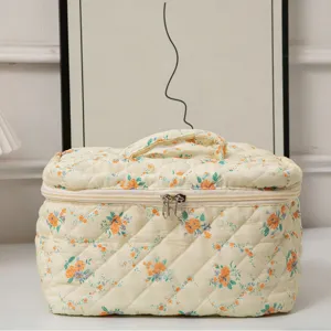 Floral quilted makeup bag with large capacity and top handle for travel storage.