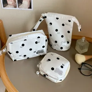 Detailed view of three polka dot pouches with pearl zipper pulls on a table