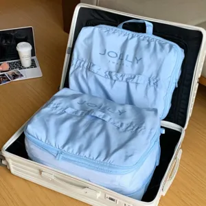 Bolsas organizadoras de viaje 5 en 1 azul claro empacadas en una maleta blanca